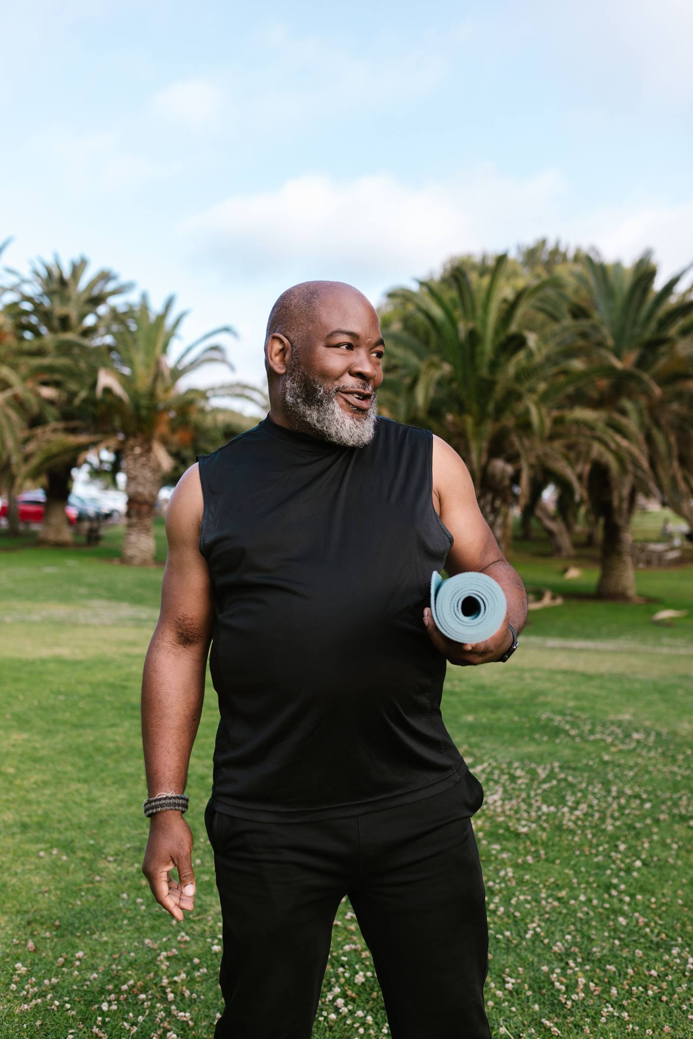 A man with a yoga mat outdoors
